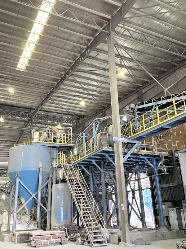 The flotation and material-separation plant: blue settling silos beneath a steel conveyor gantry and its access stairs
