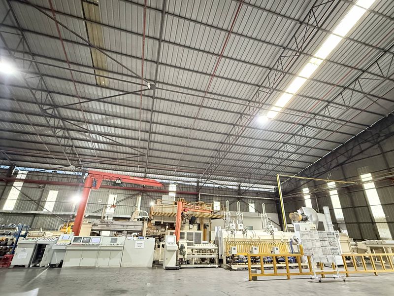 The extrusion press hall: the press line, its control desks and a jib crane under the long-span roof