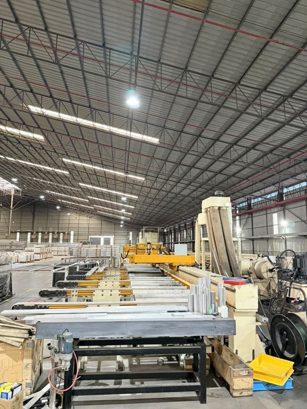The post-extrusion cutting line: run-out tables and the saw station leading down the hall
